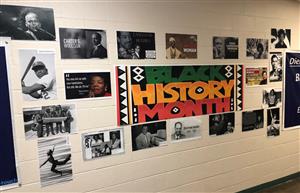 Photo shows a collection of photos of famous Black people around a central Black History Month banner. 
